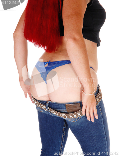 Image of Woman taking of her jeans.