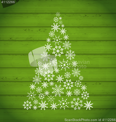 Image of Christmas pine made of snowflakes on wooden background