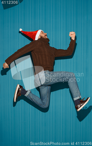Image of The running christmas man wearing a santa hat