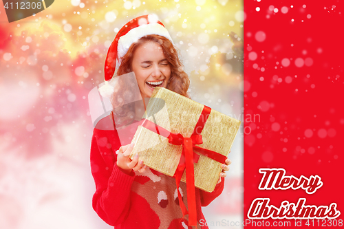 Image of Girl dressed in santa hat with a Christmas gift