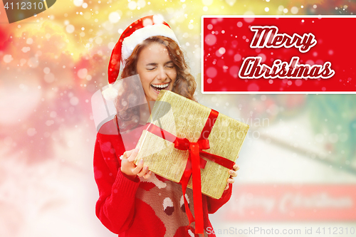 Image of Girl dressed in santa hat with a Christmas gift