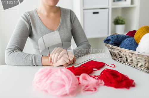 Image of woman with knitting needles and yarn in basket