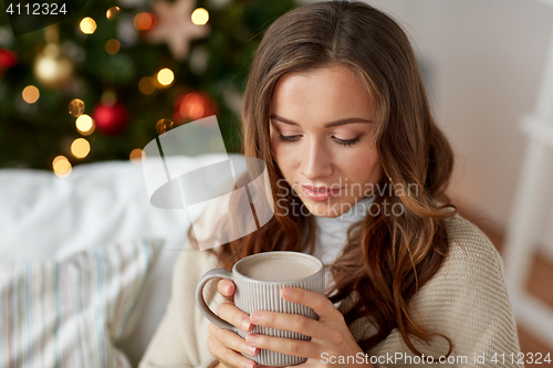 Image of happy woman drinking cocoa at home for christmas