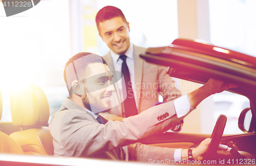 Image of happy man with car dealer in auto show or salon