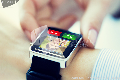 Image of close up of hands with incoming call on smartwatch