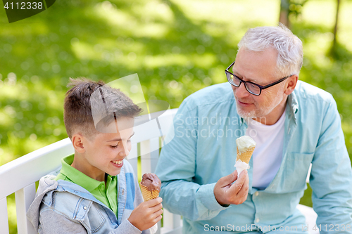 Image of old man and boy eating ice cream at summer park