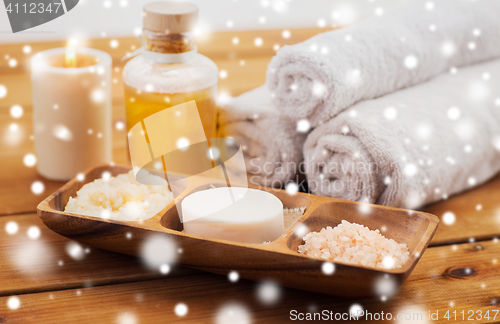 Image of soap, himalayan salt, scrub in bowl, towel and oil