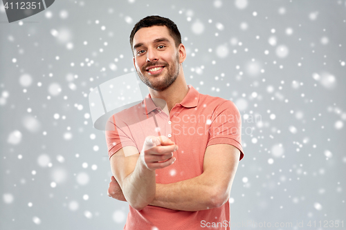 Image of man pointing finger to you over snow background