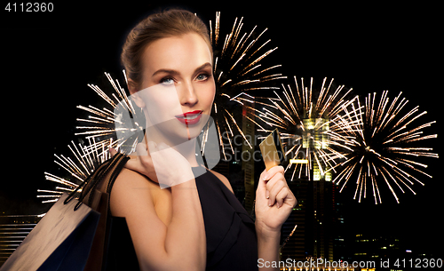 Image of woman with bank card and shopping bags on firework