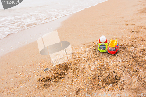 Image of Two toy cars left the children on the beach