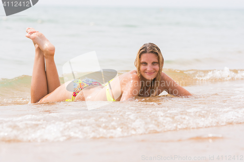 Image of Happy young beautiful girl lies on the beach