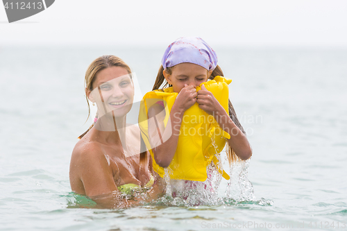 Image of She pulled out of the water his seven-year daughter, which closed hand nose in the swimming vest