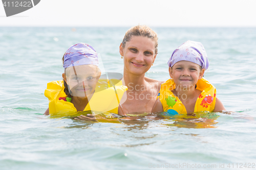 Image of Mother and two daughters swimming in the sea