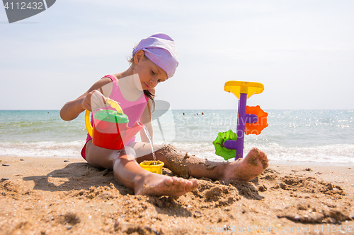 Image of The girl in panama playing sand toys on the beach