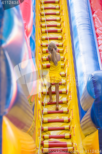 Image of Girl with a rope climbs a high hill on the trampoline