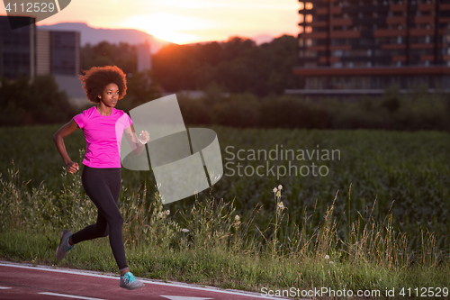 Image of a young African American woman jogging outdoors