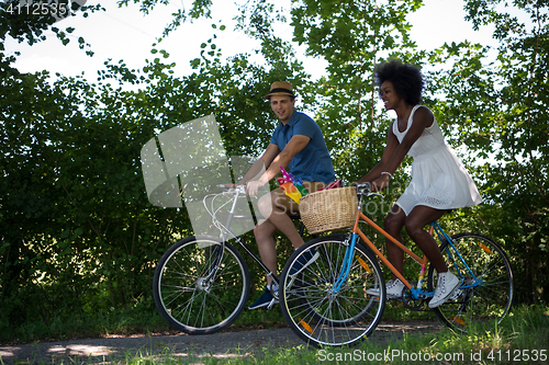 Image of Young multiethnic couple having a bike ride in nature