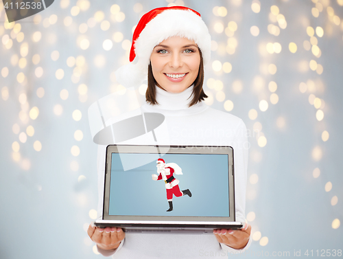 Image of woman holding laptop with santa claus on screen