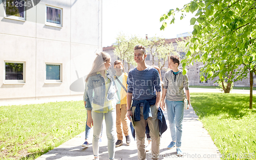 Image of group of happy teenage students walking outdoors