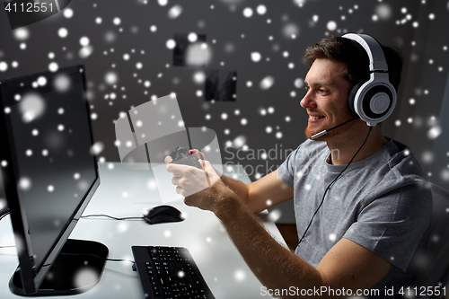 Image of man in headset playing computer video game at home