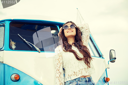 Image of smiling young hippie woman in minivan car