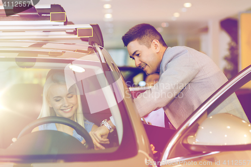 Image of happy woman with car dealer in auto show or salon