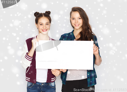 Image of smiling teenage girls holding white blank board