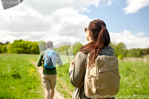 Image of happy couple with backpacks hiking outdoors