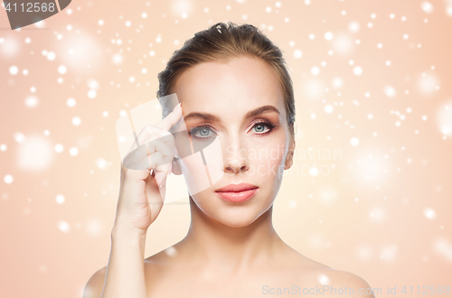 Image of beautiful woman showing her forehead over snow