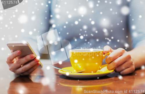 Image of woman with smartphone and coffee cup