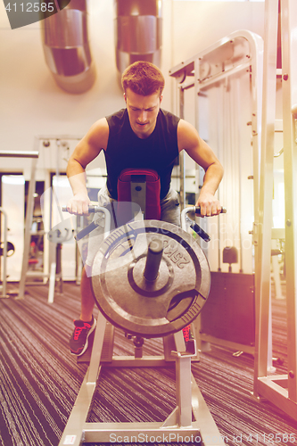 Image of young man exercising on t-bar row machine in gym