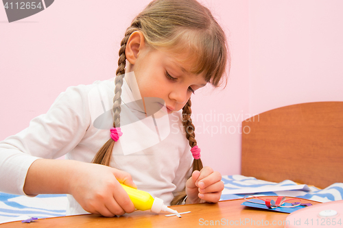 Image of Girl Apply glue to the crafts out of colored paper