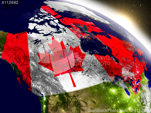 Image of Canada with flag in rising sun