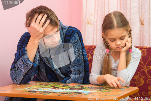 Image of The Pope is tired looking at her daughter who collects a picture from puzzles