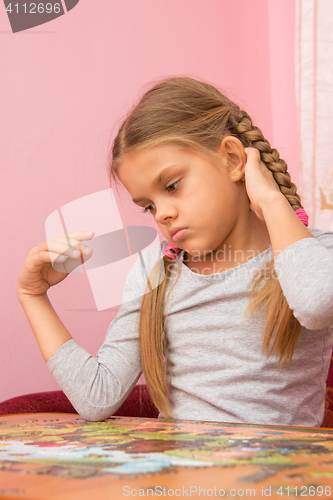 Image of Girl thinks collecting picture of puzzles