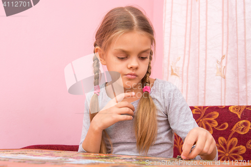 Image of The girl thought collecting picture of puzzles