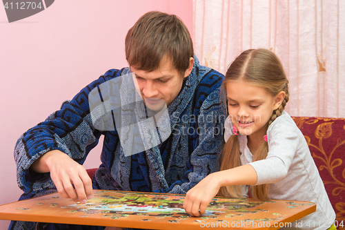 Image of Dad and daughter are passionate about collecting pictures of the puzzles