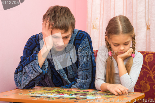 Image of My daughter collects a picture from puzzles, tired dad sitting next