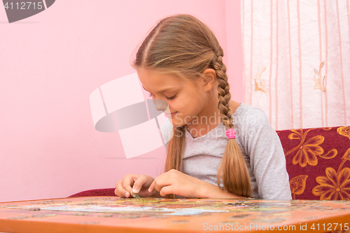 Image of Girl gladly collect picture of puzzles