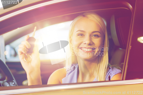 Image of happy woman getting car key in auto show or salon