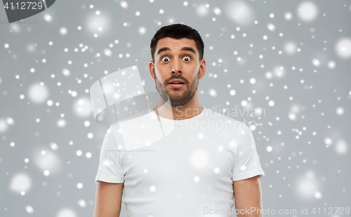 Image of scared man in white t-shirt over snow