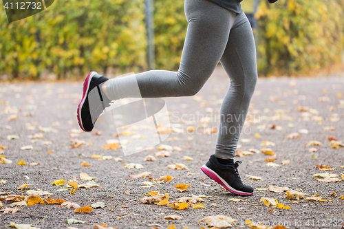 Image of close up of young woman running in autumn park