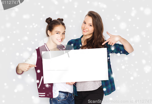 Image of smiling teenage girls holding white blank board