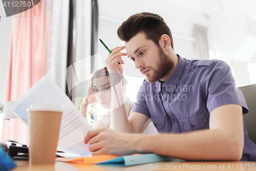 Image of creative team with computer and papers in office