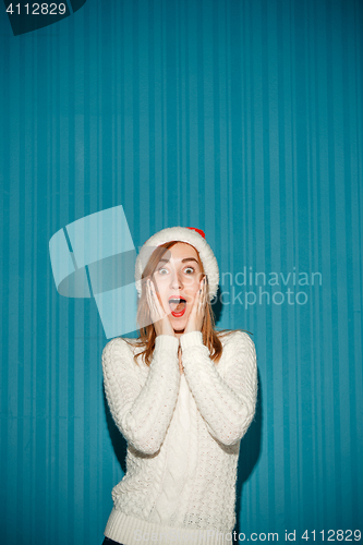 Image of Surprised christmas girl wearing a santa hat