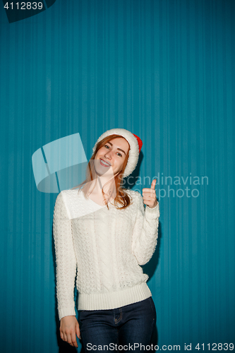 Image of Surprised christmas girl wearing a santa hat