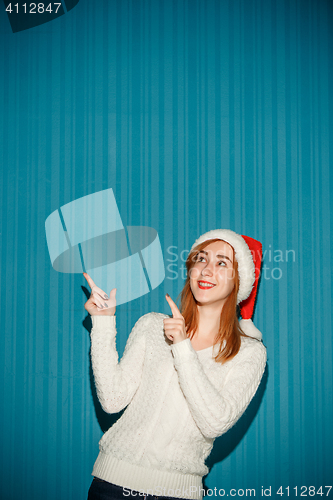 Image of Surprised christmas girl wearing a santa hat