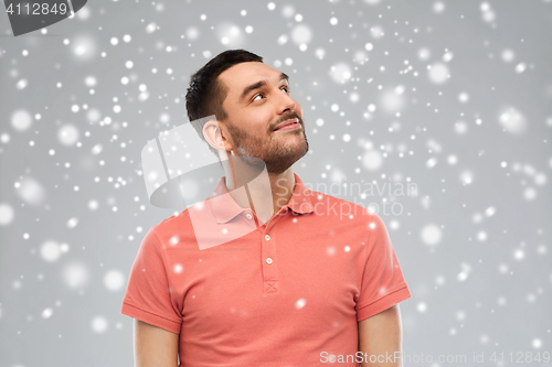 Image of smiling man looking up over snow background