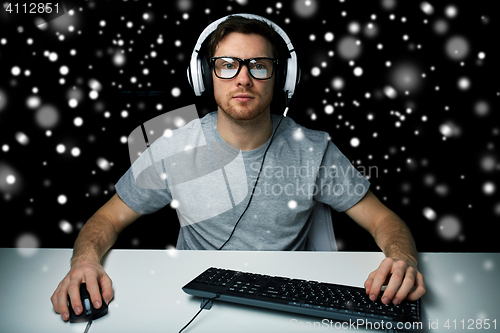 Image of man in headset playing computer video game