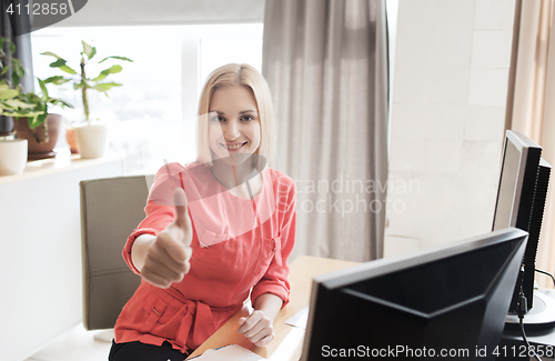 Image of happy creative female office worker with computers